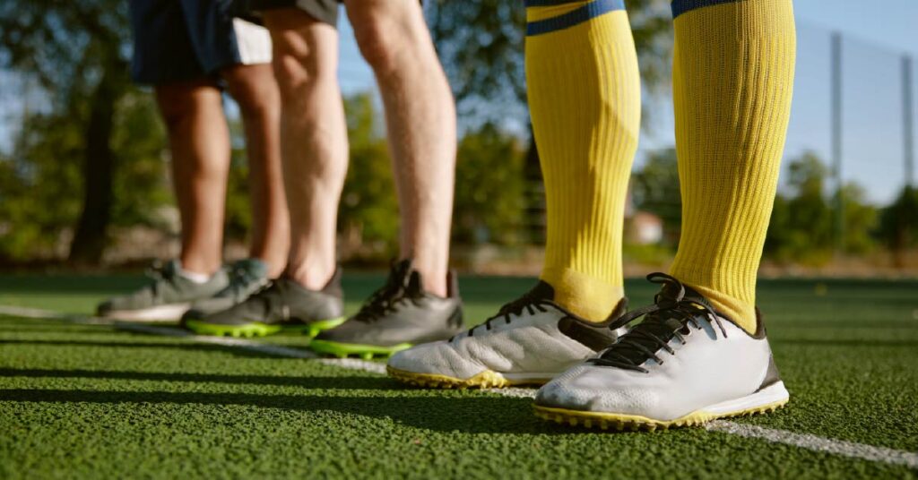 Botines de fútbol diseñados para césped artificial con suela de tacos pequeños y materiales resistentes